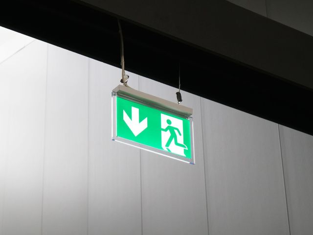 emergency exit or fire escape sign with running man symbol and arrow