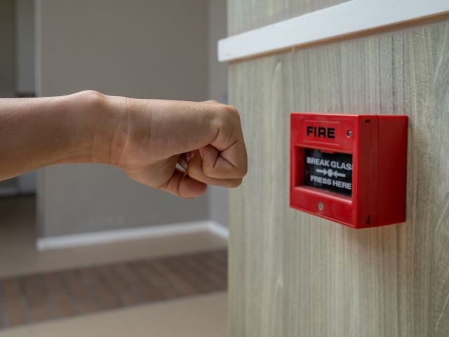 Fire alarm box with human hand action to crush the glass for emergency situation.