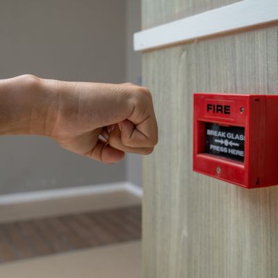 Fire alarm box with human hand action to crush the glass for emergency situation.